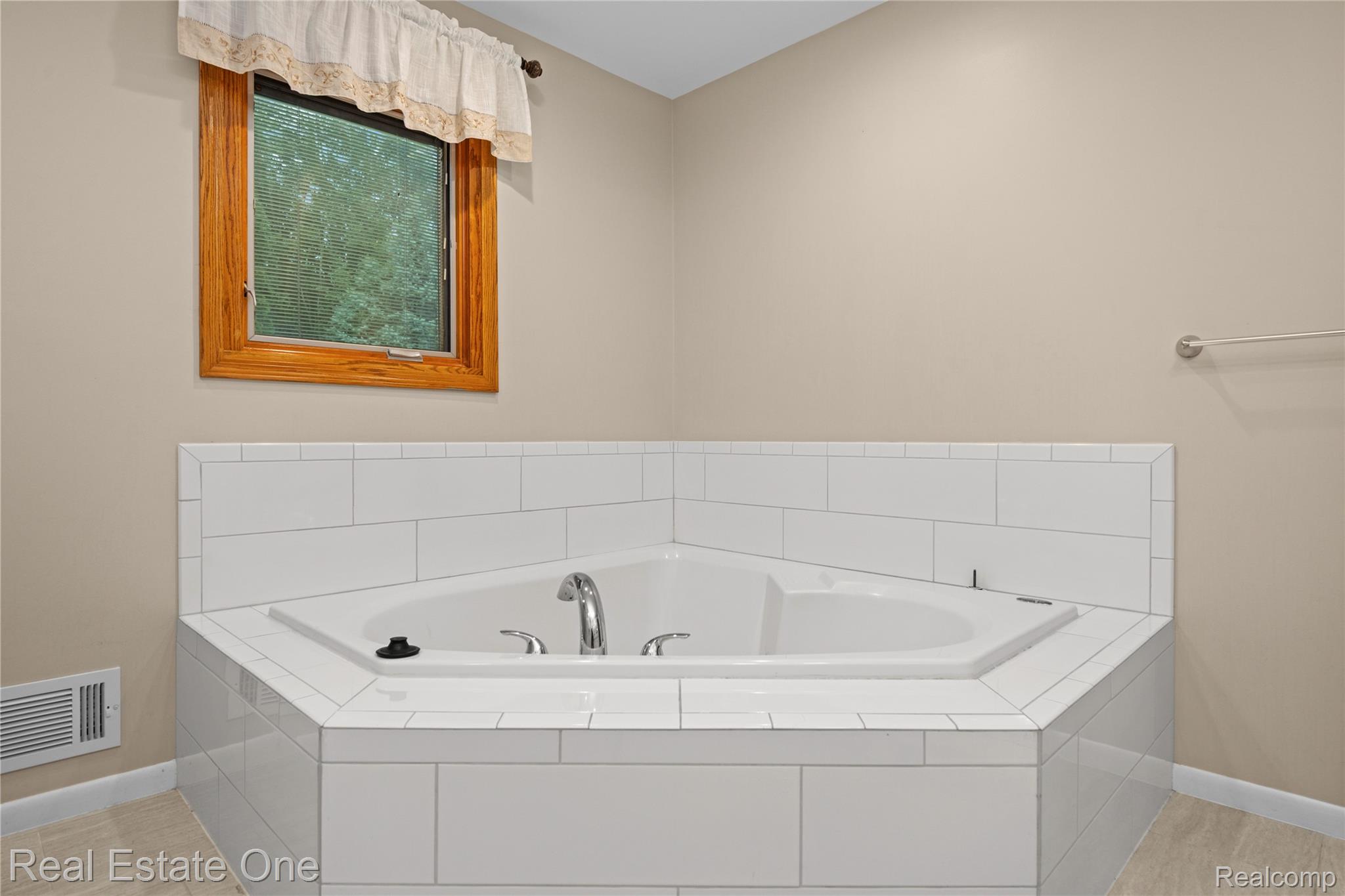 39750 Cheviot Road Canton, MI 48188 - Photo 41 of 71 Corner soaking tub with white subway tile surround and chrome fixtures