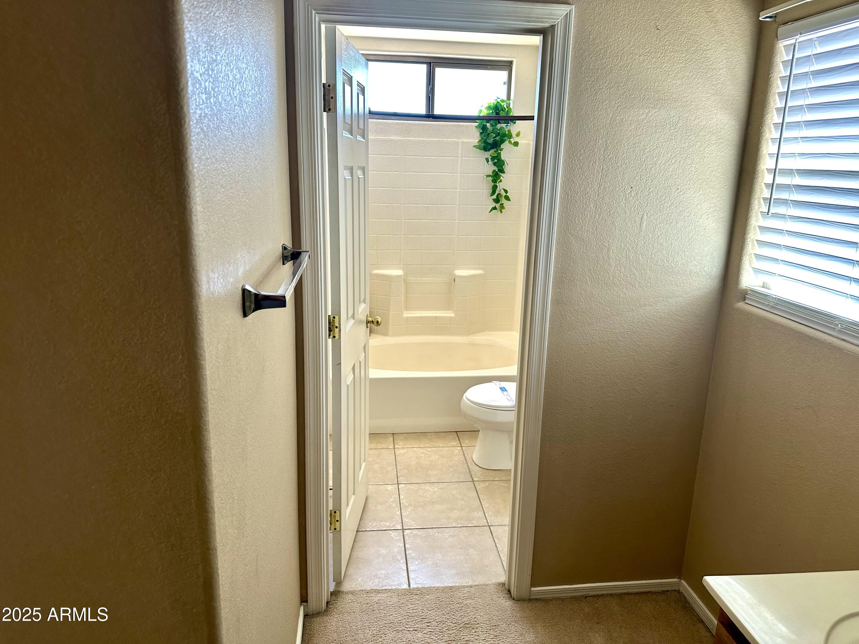 592 East 9th Avenue Apache Junction, AZ 85119 - Photo 16 of 19 a view of a bathroom with a glass door and a window