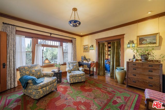 a living room with a baby crib furniture and a window