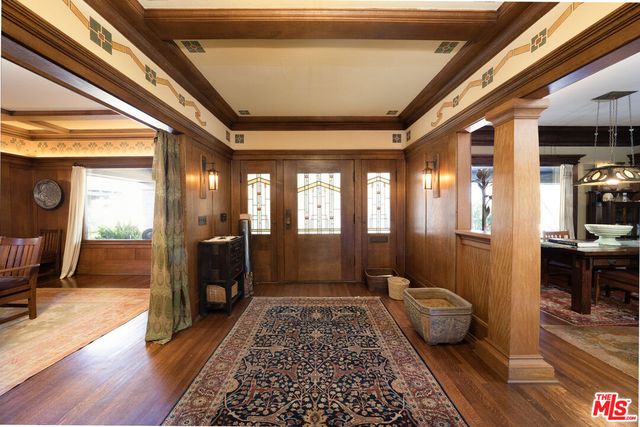 a view of a hallway with wooden floor and couches