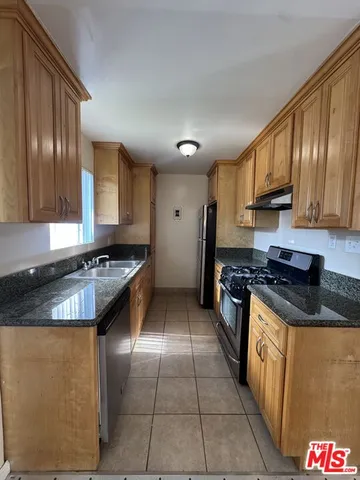 a kitchen with granite countertop a stove sink and cabinets