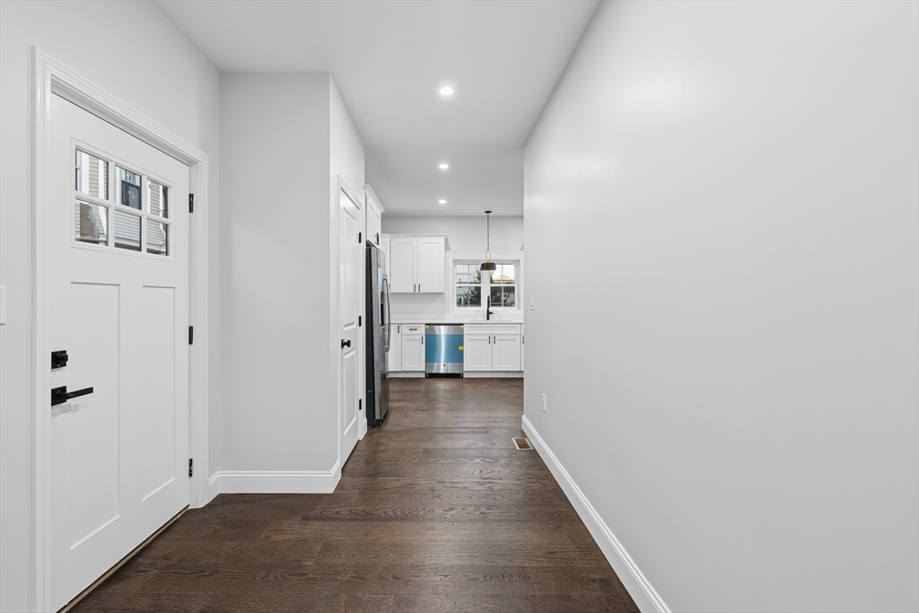 138 18th Street Fall River, MA 02723 - Photo 11 of 14 a view of a hallway with wooden floor and a kitchen
