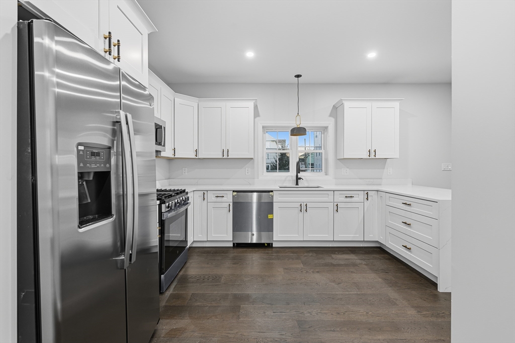 138 18th Street Fall River, MA 02723 - Photo 5 of 14 a kitchen with white cabinets and stainless steel appliances