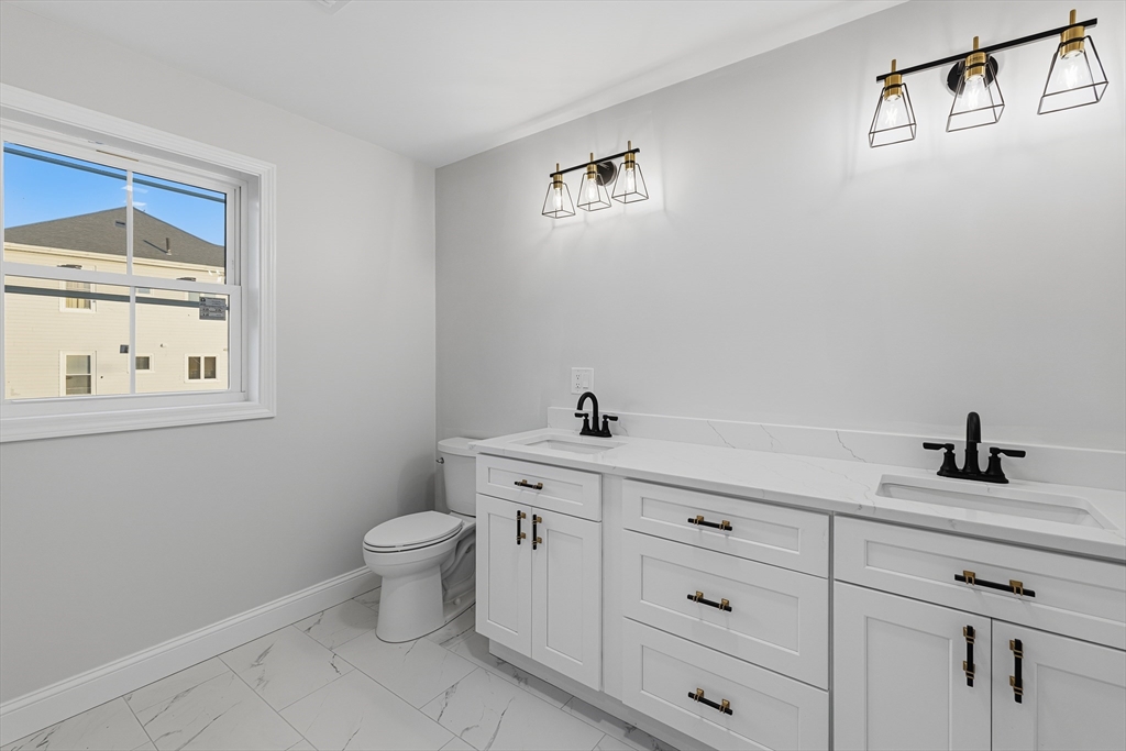 138 18th Street Fall River, MA 02723 - Photo 6 of 14 a bathroom with a toilet a sink a vanity and mirror