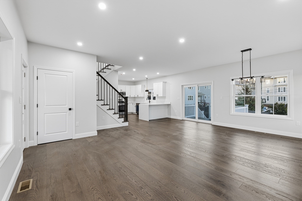 138 18th Street Fall River, MA 02723 - Photo 7 of 14 a view of an empty room with wooden floor kitchen view and a window