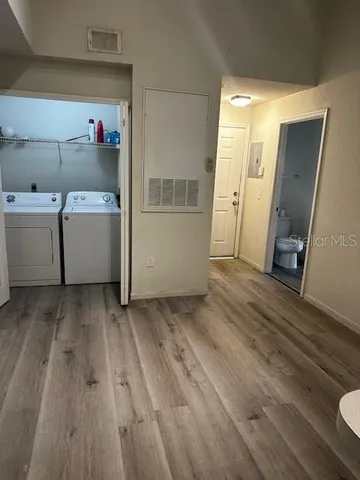 a view of utility room with closet and wooden floor