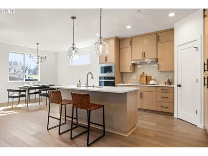 a kitchen with kitchen island granite countertop a sink cabinets and wooden floor