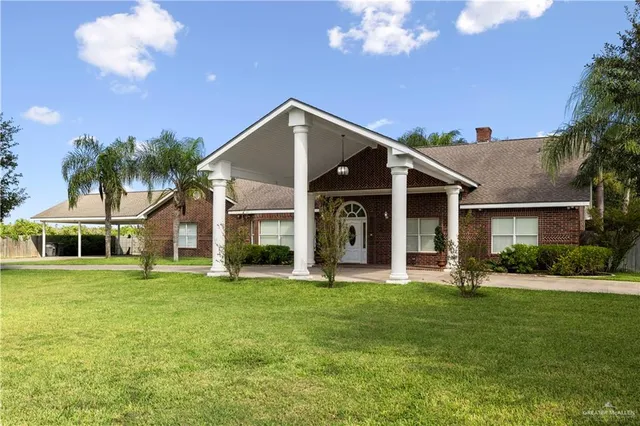 a front view of a house with a yard and trees
