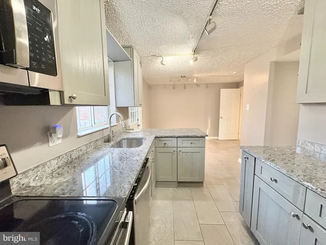 a kitchen with stainless steel appliances granite countertop a sink stove and cabinets
