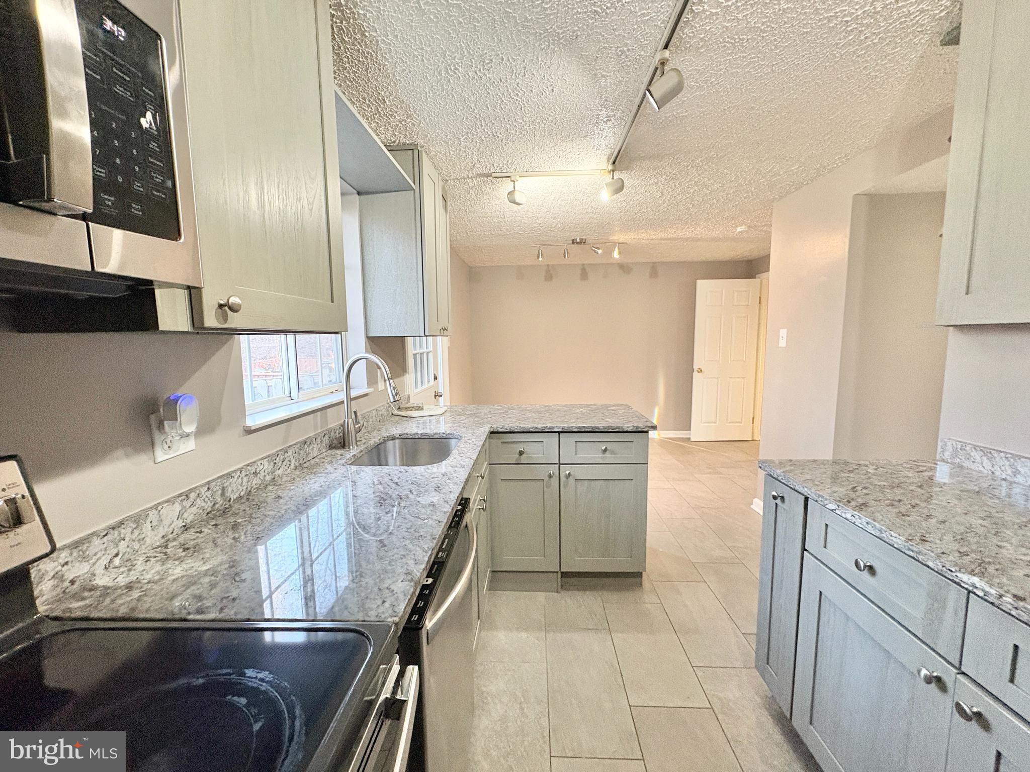 8263 Burning Forest Court Springfield, VA 22153 - Photo 11 of 43 a kitchen with stainless steel appliances granite countertop a sink stove and cabinets