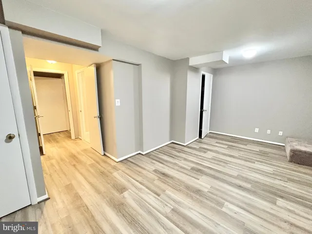 a view of a livingroom with wooden floor and bathroom