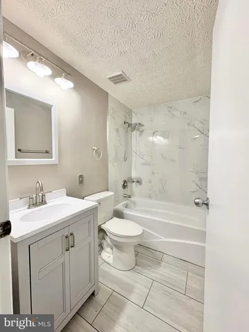 a bathroom with a double vanity sink toilet mirror and bathtub