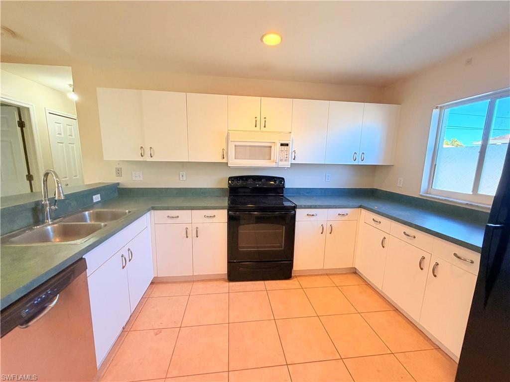8397 Bahamas Road Fort Myers, FL 33967 - Photo 12 of 37 Kitchen with black appliances, dark countertops, white cabinetry, light tile patterned floors, and recessed lighting