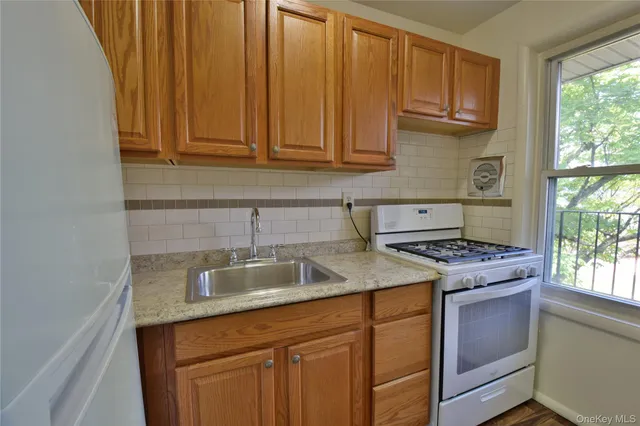 a kitchen with granite countertop a sink stove and cabinets