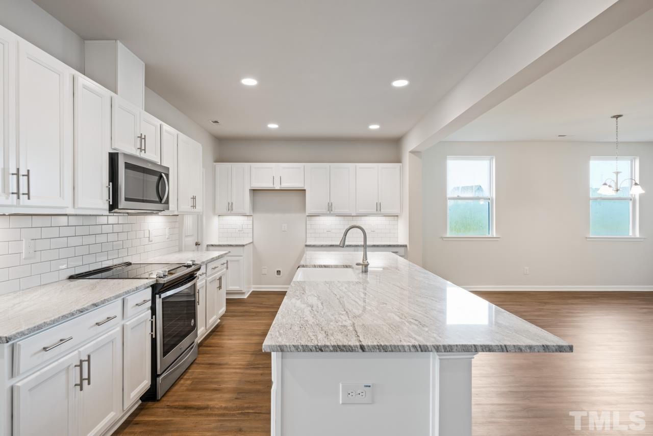 129 Scoville Road Garner, NC 27529 - Photo 2 of 25 a large kitchen with stainless steel appliances granite countertop a large counter top and a stove top oven