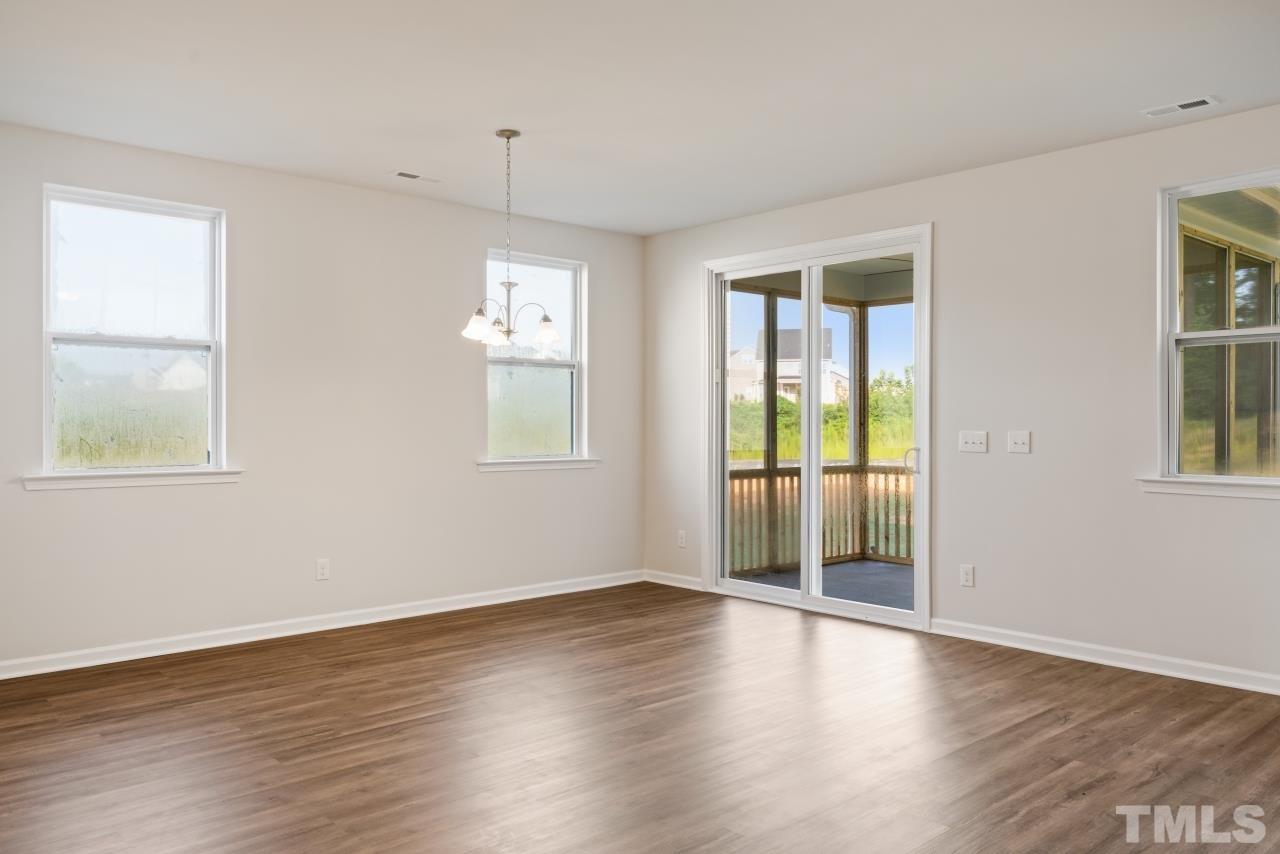 129 Scoville Road Garner, NC 27529 - Photo 11 of 25 a view of an empty room with wooden floor and a window