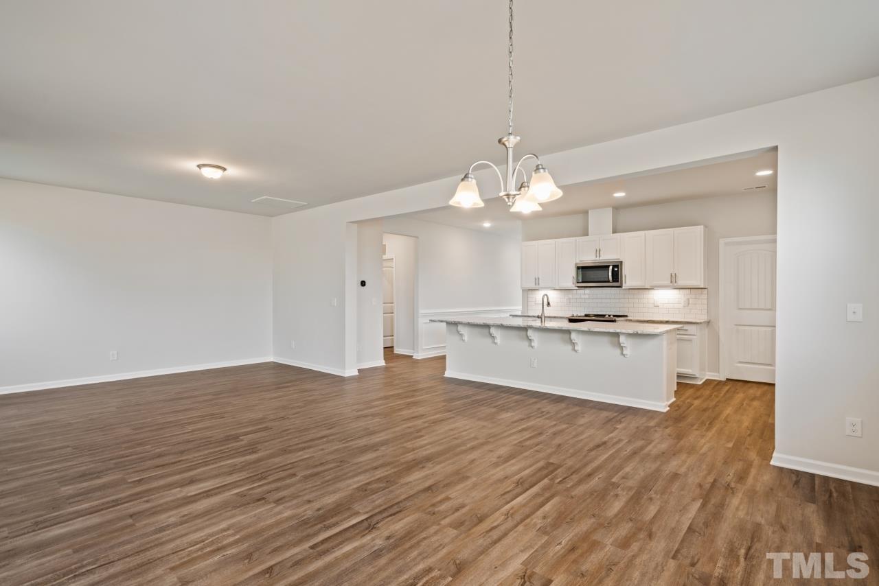 129 Scoville Road Garner, NC 27529 - Photo 18 of 25 a large kitchen with cabinets wooden floor and stainless steel appliances