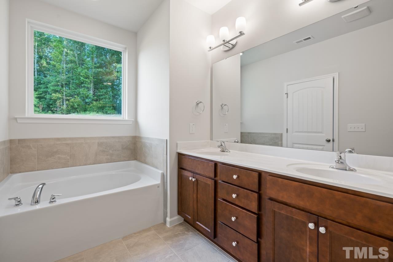 129 Scoville Road Garner, NC 27529 - Photo 19 of 25 a bathroom with a tub double sink and a mirror