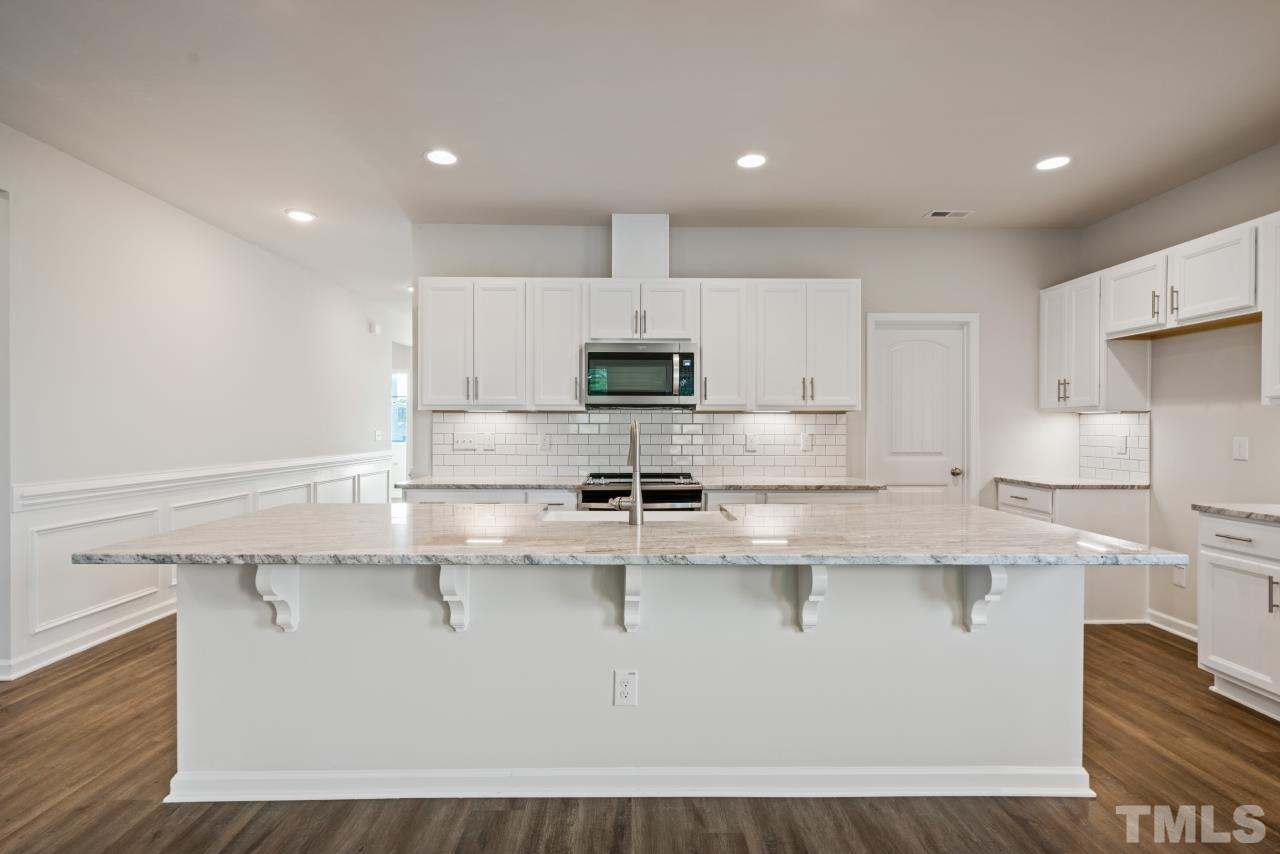 129 Scoville Road Garner, NC 27529 - Photo 8 of 25 a kitchen with kitchen island granite countertop a sink window and stainless steel appliances