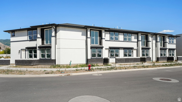 717 South Harrison Drive West Springville, UT 84663 - Photo 2 of 31 Modern multi-family building featuring a white stucco facade and dark-framed windows