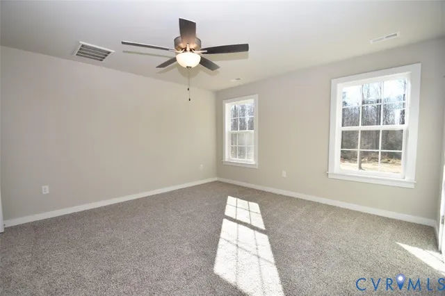 an empty room with windows and fan