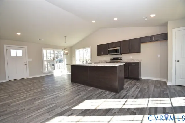 a kitchen with stainless steel appliances kitchen island granite countertop a stove a sink and a refrigerator