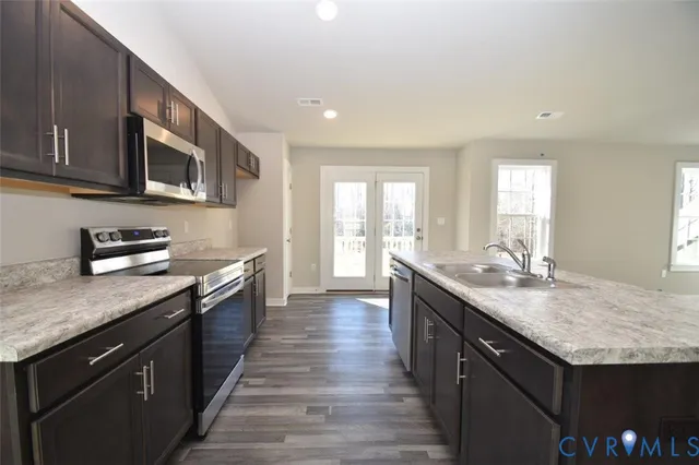 a kitchen with stainless steel appliances granite countertop a sink stove and cabinets
