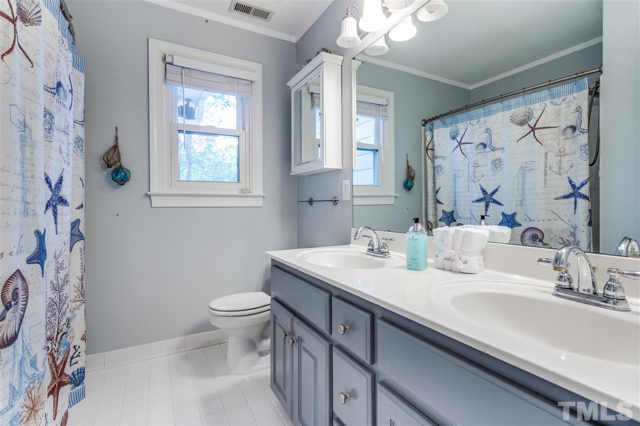 9401 Floral Ridge Court Raleigh, NC 27613 - Photo 14 of 25 a bathroom with a sink a toilet and a large mirror