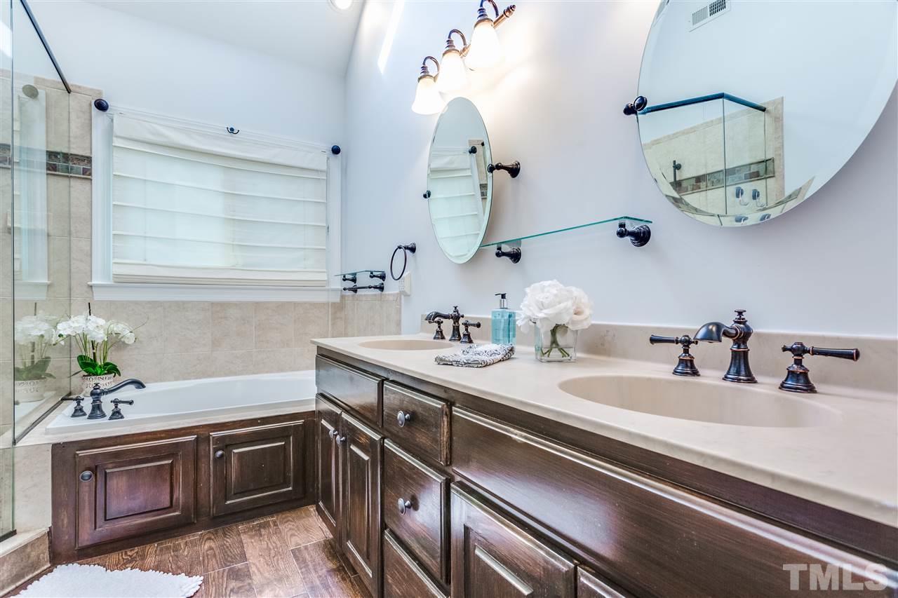 9401 Floral Ridge Court Raleigh, NC 27613 - Photo 17 of 25 a bathroom with a sink and a mirror