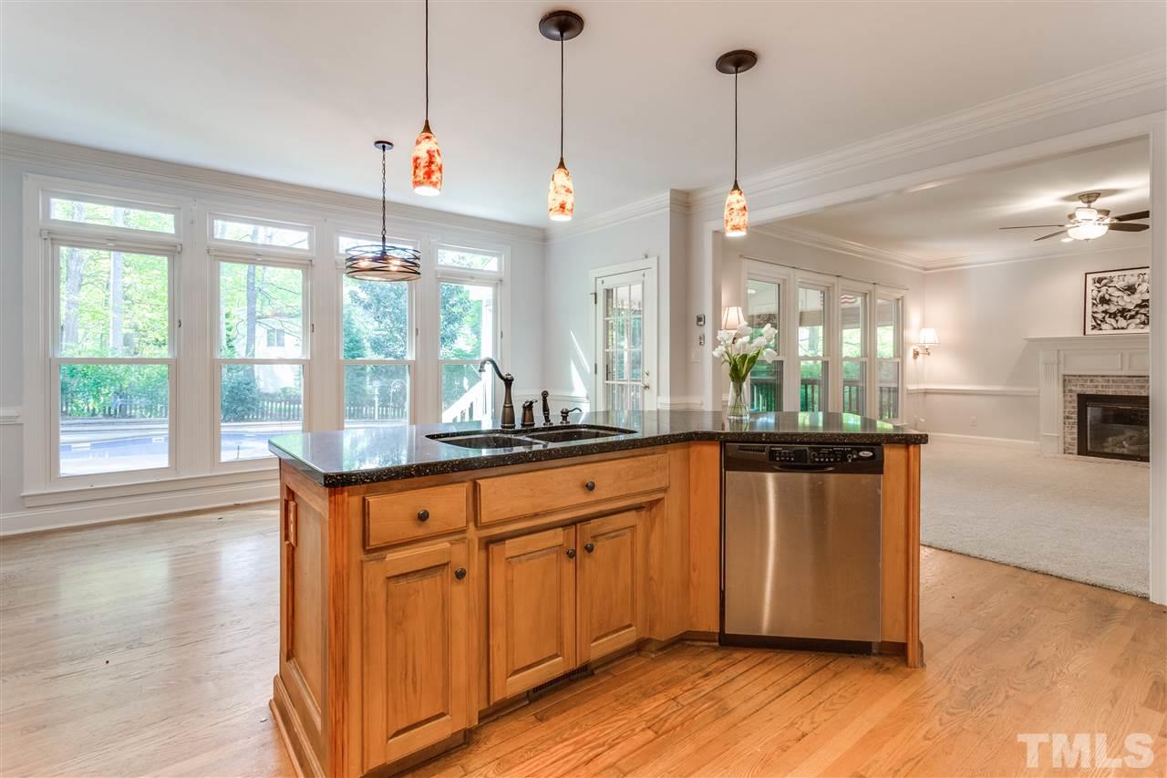 9401 Floral Ridge Court Raleigh, NC 27613 - Photo 9 of 25 a kitchen with stainless steel appliances granite countertop wooden floors sink and cabinets