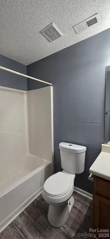 a white toilet sitting next to a bath tub and a shower