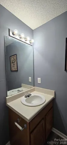 a sink sitting under a bathroom mirror