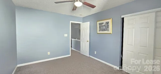 an empty room with a ceiling fan and a window