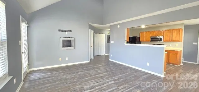 a view of a kitchen with wooden floor and a window