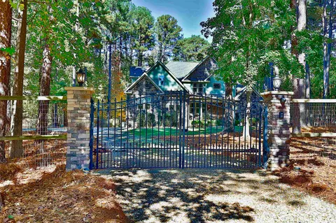 a view of a house with a small yard and a large tree