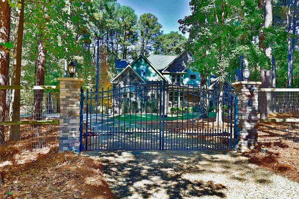 a view of a house with a small yard and a large tree