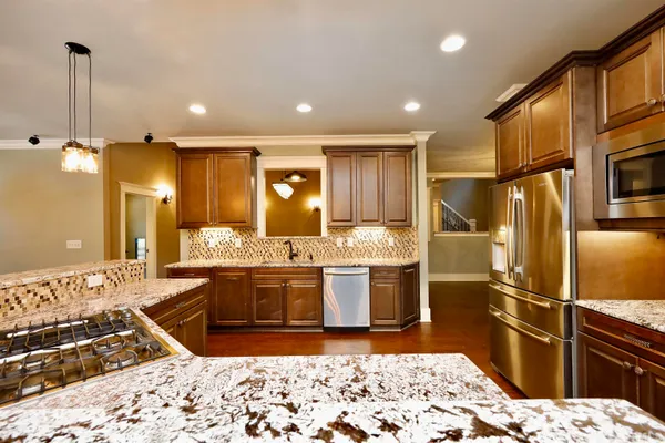 a kitchen with stainless steel appliances granite countertop a sink stove and refrigerator