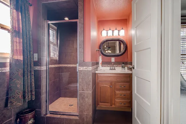 a bathroom with a sink a toilet and shower