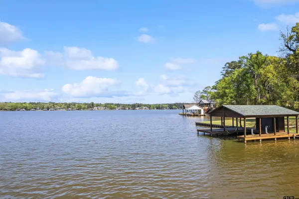 an aerial view of lake residential house with outdoor space and trees around