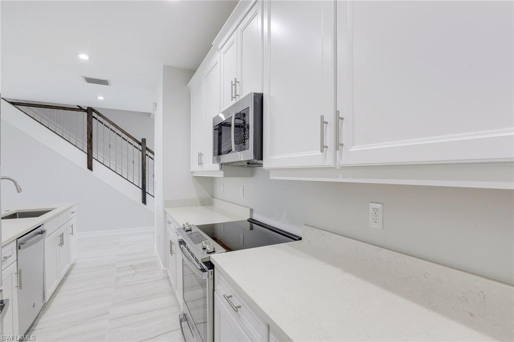 7473 Rockefeller Drive Naples, FL 34119 - Photo 6 of 19 a kitchen that has a sink and a stove in it