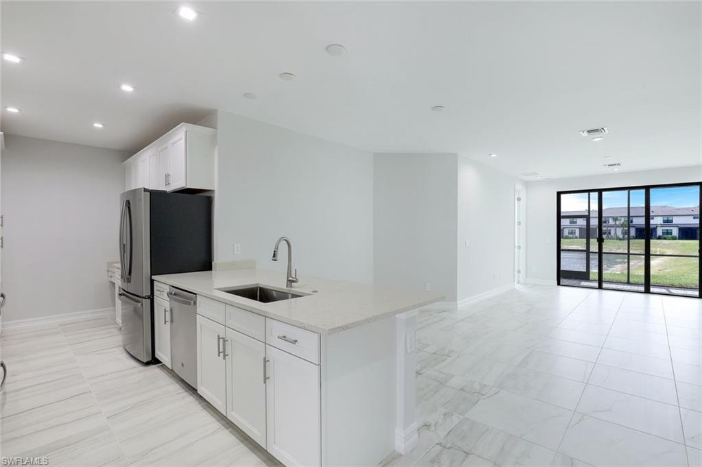 7473 Rockefeller Drive Naples, FL 34119 - Photo 8 of 19 a kitchen with stainless steel appliances granite countertop a sink and a refrigerator