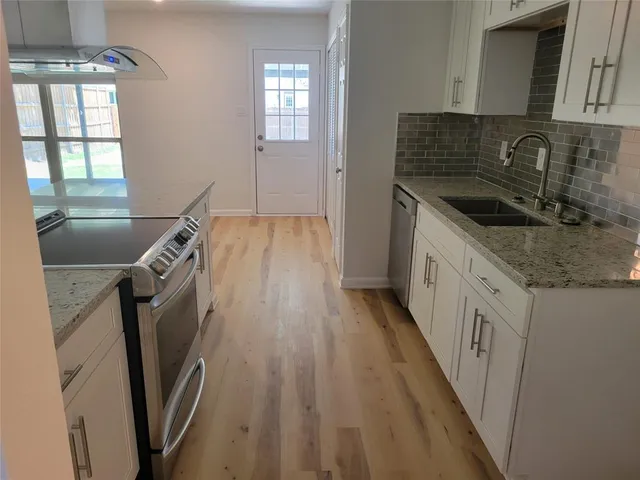 a kitchen with a sink a refrigerator and window