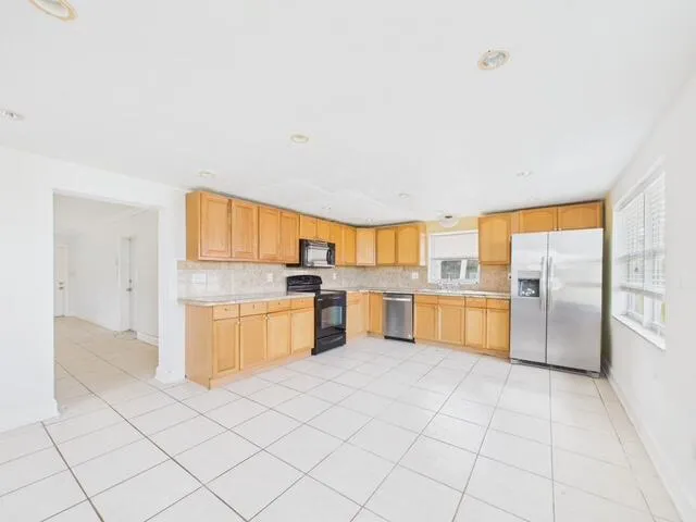 a kitchen with a sink window and cabinets