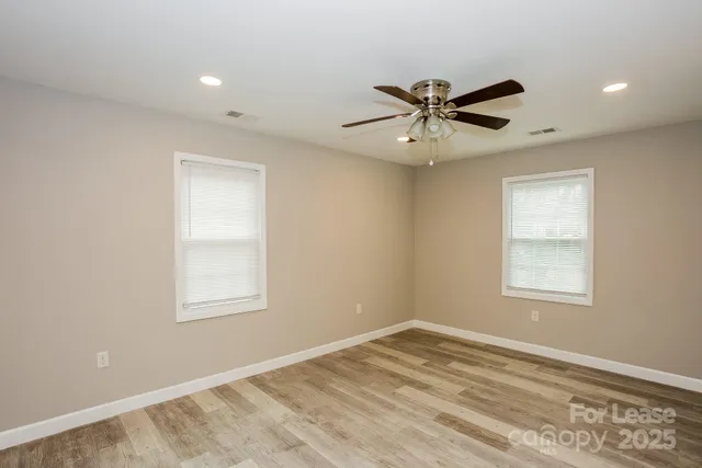 an empty room with closet and a ceiling fan