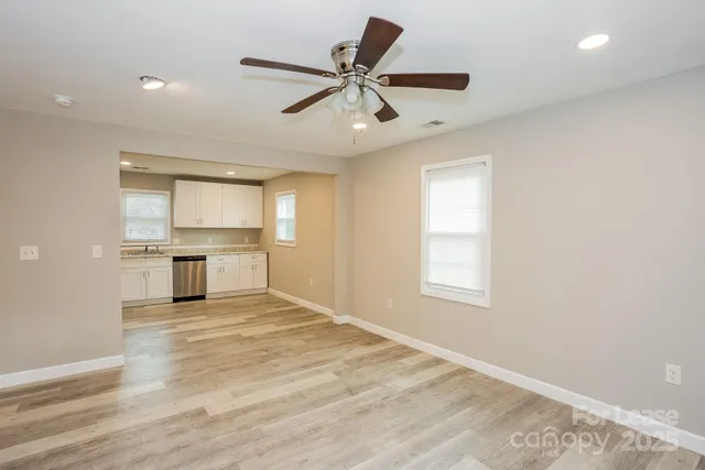 a kitchen with stainless steel appliances granite countertop white cabinets a sink a stove a refrigerator and a microwave