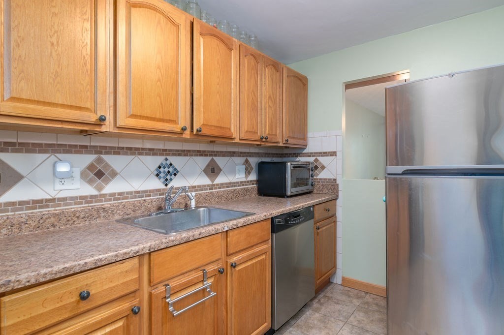 a kitchen with stainless steel appliances granite countertop a refrigerator and a sink