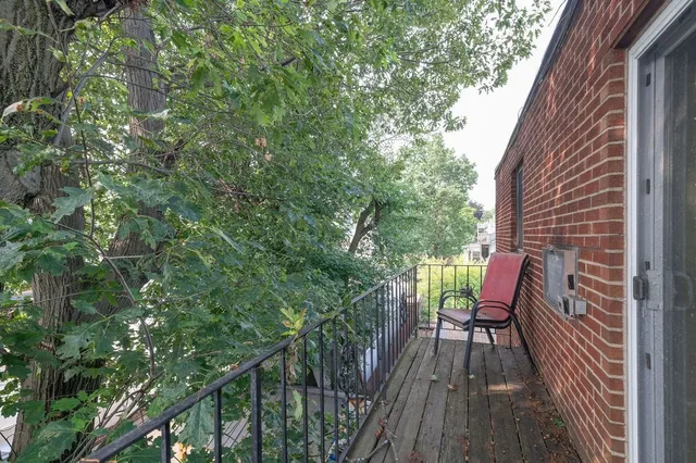 a balcony with wooden floor and outdoor seating