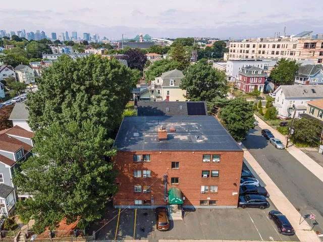 an aerial view of multiple houses with a yard
