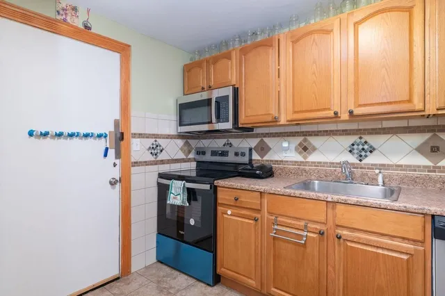 a kitchen with stainless steel appliances granite countertop a stove a sink and a microwave