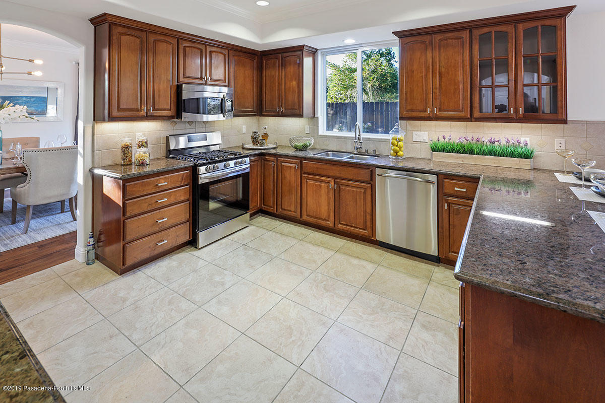 7215 Summitrose Street Tujunga, CA 91042 - Photo 14 of 47 a kitchen with stainless steel appliances granite countertop a sink stove and cabinets